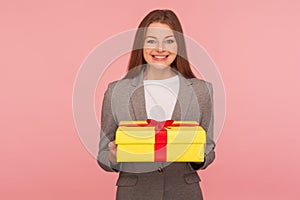 Portrait of joyful happy elegant businesswoman in suit jacket holding present and smiling, celebrating anniversary photo