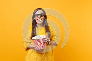 Portrait of joyful happy young girl in 3d imax glasses watching movie film and eating popcorn from bucket isolated on