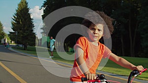 Portrait of joyful preschool child cycling outdoors