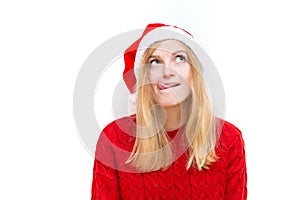 Portrait of joyful pretty woman, emotional girl in santa claus christmas hat showing tongue at the camera. Holiday
