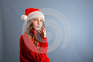 Portrait of joyful pretty woman in red santa claus hat laughing isolated on gray background. Beautiful girl looking happy and