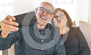 Portrait of joyful senior married couple - Retired couple enjoying free time taking funny selfie - middle-aged couple having fun