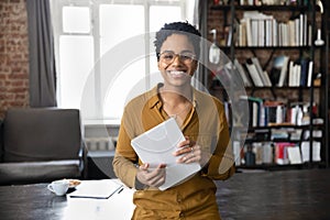 Portrait of joyful young African American woman holding digital tablet.