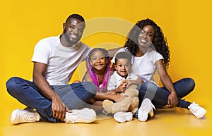 Portrait of joyful young afro family with two little kids