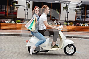 Portrait of a joyful young couple riding on a motorbike