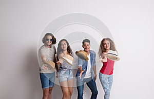 Portrait of joyful young group of friends with hats standing in a studio.