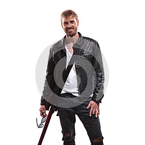 Portrait of joyful young guitarist holding his sunglasses