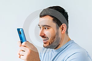 Portrait of a joyful young man holding smartphone