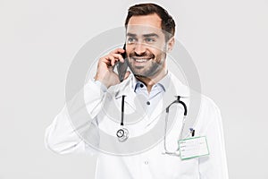 Portrait of joyful young medical doctor with stethoscope working in clinic and talking on cellphone