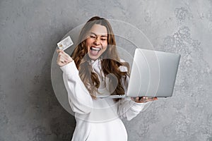 Portrait of a joyful young woman using laptop computer
