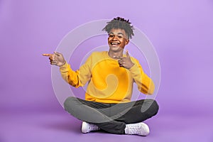 Portrait of joyous african american guy smiling and pointing fin