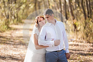 Portrait of just married wedding couple. happy bride, groom standing on beach, kissing, smiling, laughing, having fun in autumn pa