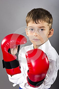 Portrait of a karate kid wearing red gloves ready to fight