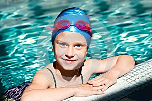 Portrait of a kid laughing in a swimming pool.