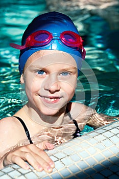 Portrait of a kid laughing in a swimming pool.