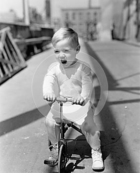 Portrait of kid riding tricycle