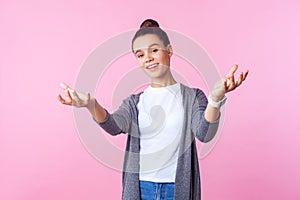 Portrait of kind good-natured brunette teenage girl raising arms in gesture give me hug. isolated on pink background