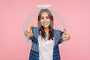 Portrait of kind positive girl with nimbus over head stretching arms to camera with friendly generous smile