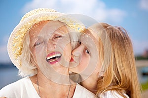 Portrait of Kissing Grandmother and Granddaughter looking at the