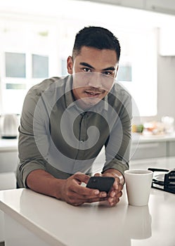 Portrait, kitchen and man online with smartphone for trending updates or popular topics on social media or internet