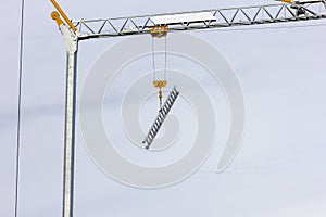 A portrait of a ladder hanging on a crane`s grapling hook so it would not get stolen.