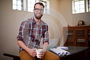 Portrait, laptop and architect in office with smile for career in construction industry and coffee. Man, contractor and