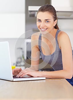 Portrait, laptop and online shopping with a woman in the kitchen of her home for ecommerce in the morning. Computer