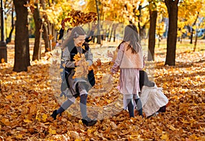 portrait of a large family with children in an autumn city park, happy people playing together and throwing yellow leaves,