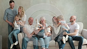 Portrait of large family of three generations sitting on sofa in living room