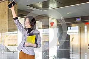 portrait of a Latin businesswoman celebrating a success outside her office