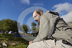 Portrait of a latin female hiker posing smiling beside a stream at a campsite