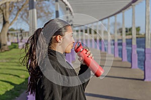 Portrait of a Latin girl drinking water from a bottle