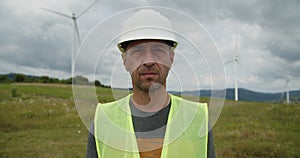 Portrait of latin professional man standing on wind turbine field