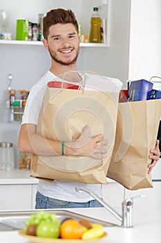 Portrait latin young man holding grocery shopping bags