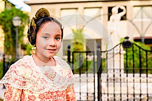 Portrait of a latina fallera girl wearing the traditional valencian costume of Fallas photo