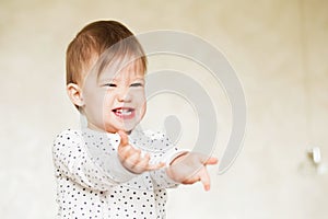 Portrait of a laughing baby girl in pajamas.