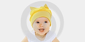 Portrait of laughing baby wearing a yellow hat on a white background