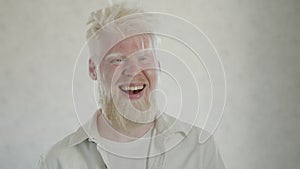 Portrait of laughing bearded man with albinism on white background. Albinos