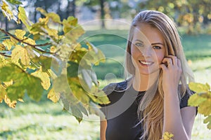 Portrait of laughing beautiful young girl posing in autumn par