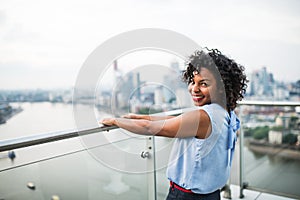 A portrait of a woman standing on a terrace in London. Copy space.