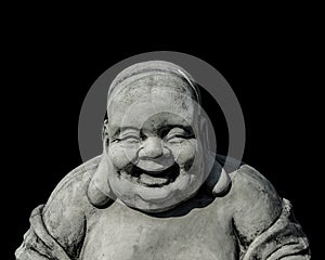 Portrait of a laughing buddha statue, islated on black background. Sign for peace and wisdom