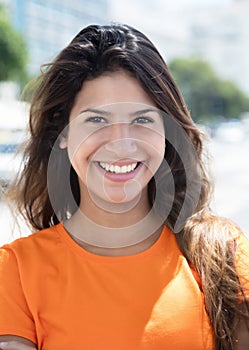 Portrait of a laughing caucasian woman in a orange shirt in the