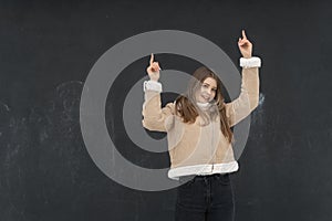 Portrait of laughing girl in studio dressed in short beige sheepskin coat. Young woman in stylish comfortable outerwear