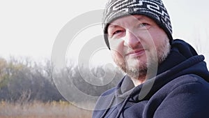 Portrait of a laughing handsome middle-aged man of European appearance in a hat outdoors, slow motion. Mature Caucasian