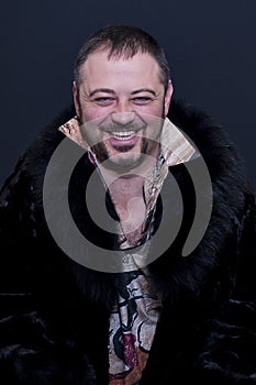 Portrait of laughing man with colored shirt and black fur coat