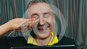 Portrait Laughing Man in Glasses Reading a Tablet Computer