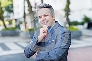 Portrait of laughing mature businessman with suit and gray hair