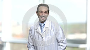 Portrait of laughing mature man in lab coat.