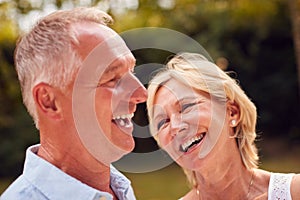 Portrait Of Laughing Senior Couple In Garden At Home Together