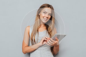 Portrait of a laughing woman using tablet computer isolated